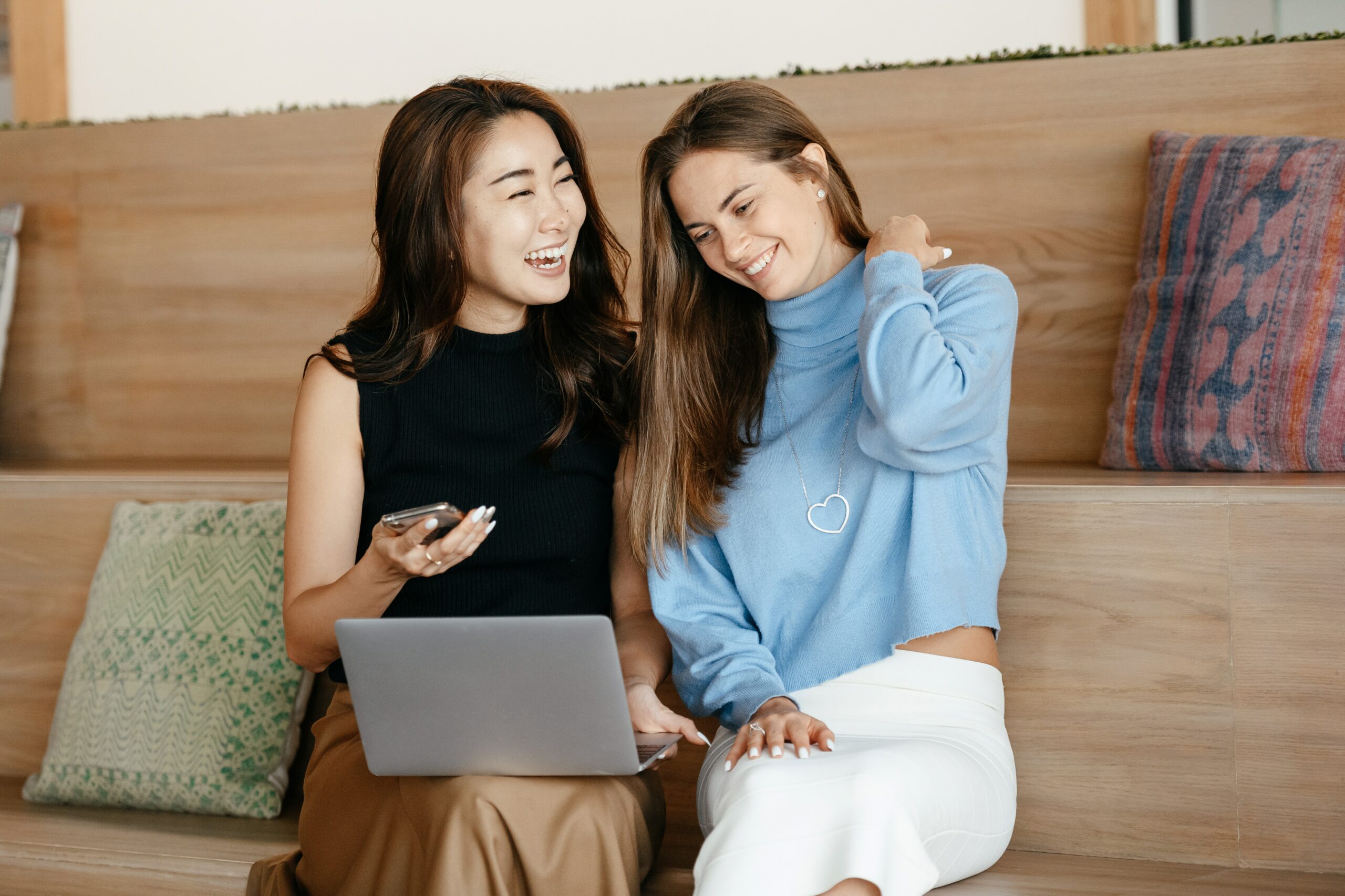 two-women-using-a-laptop-in-living-room