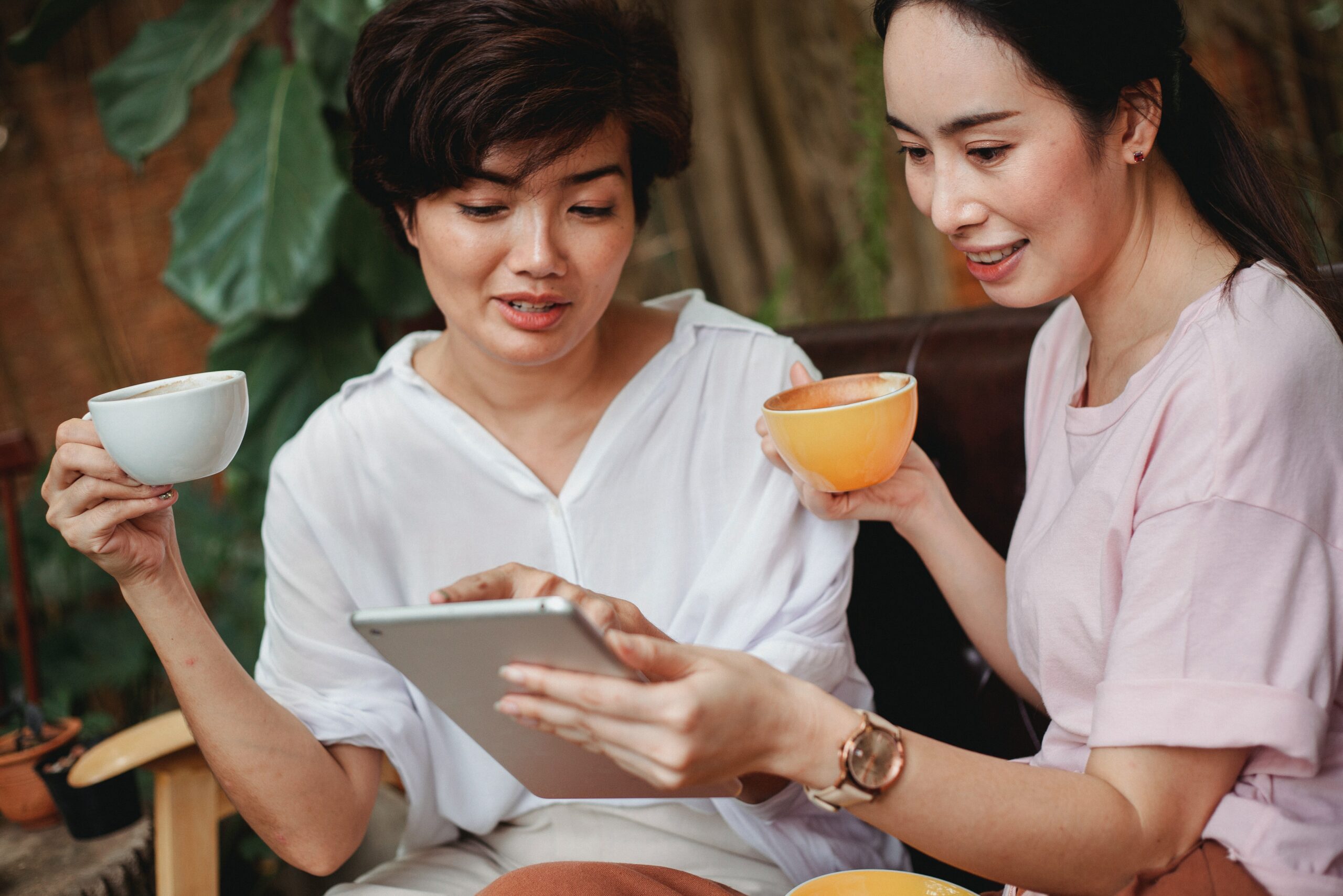 women-drinking-tea-while-checking-the-ipad